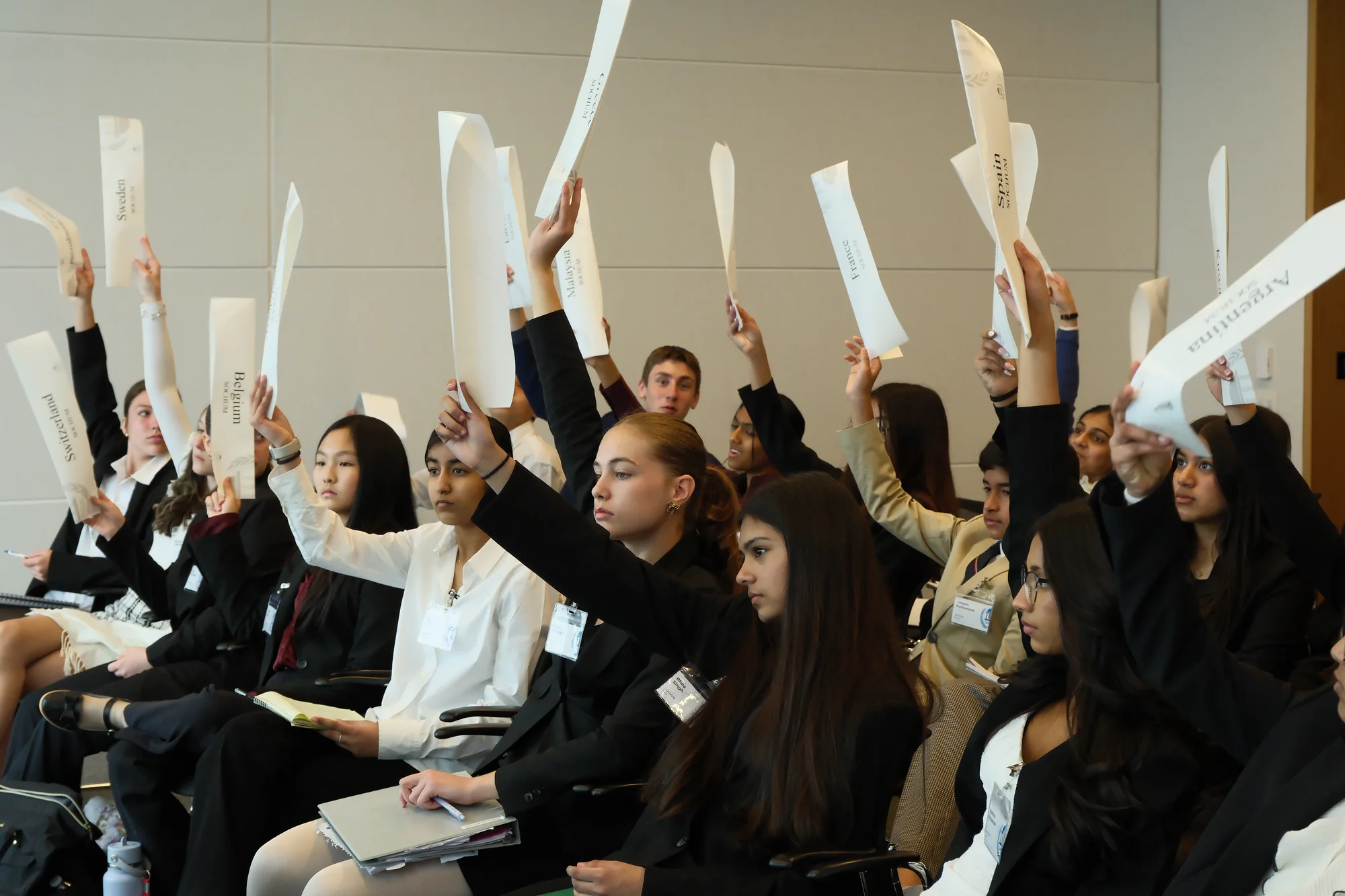 JAMUN Model UN delegates raise placards to vote on a resolution.